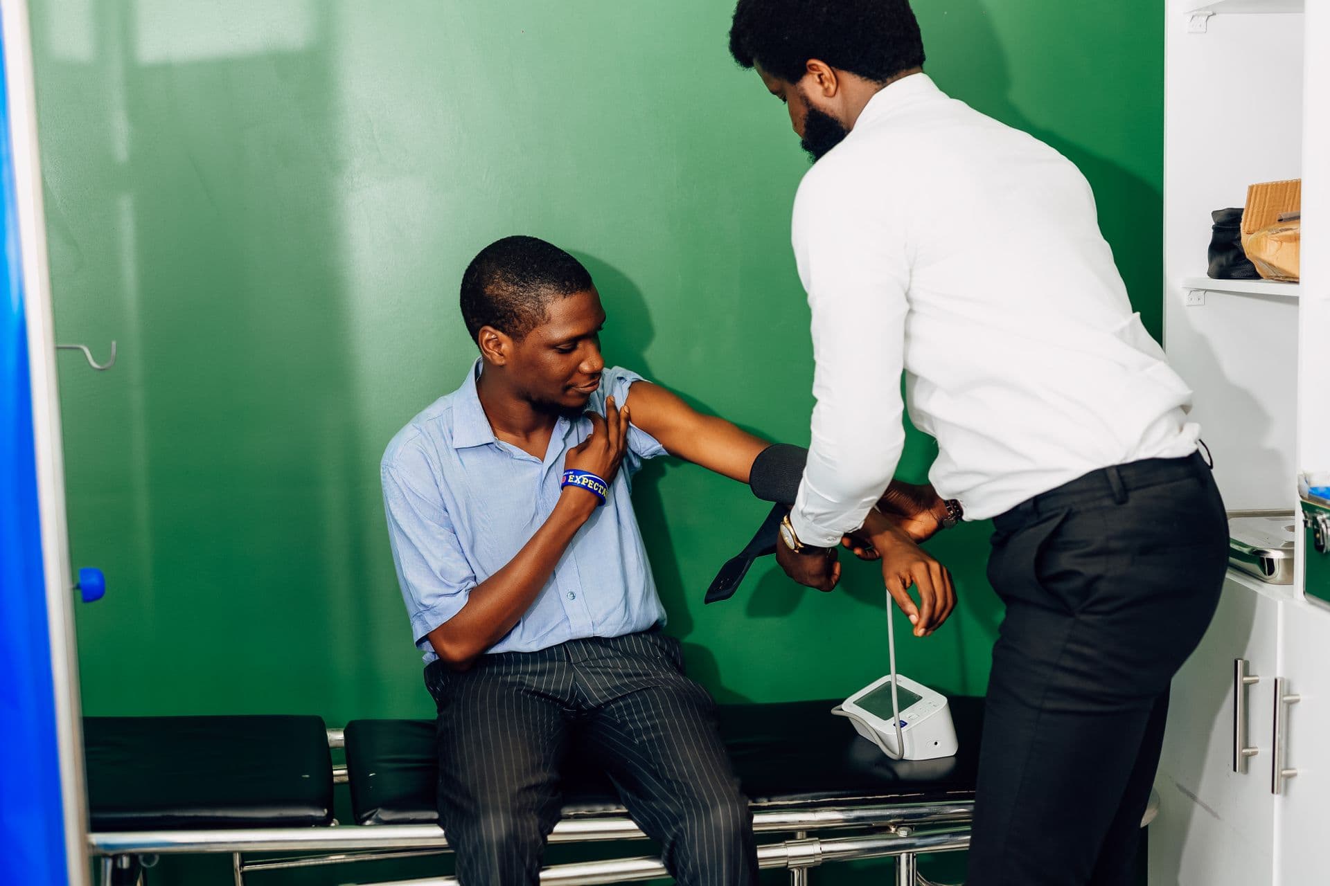 A clinician checking a patient's blood pressure during a follow-up visit.